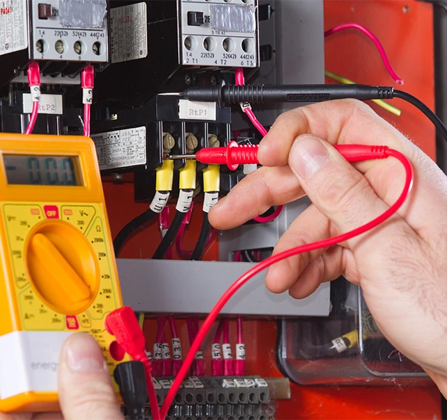 Electrician testing a commercial electrical panel