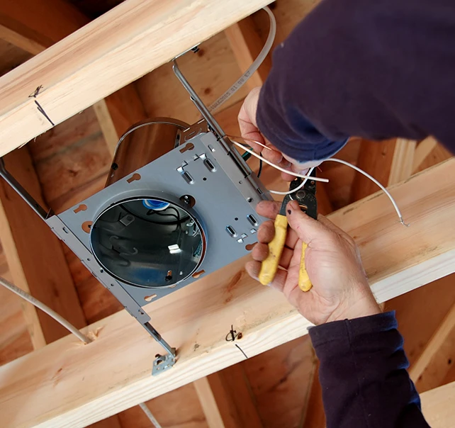 Electrician installing residential ceiling wiring